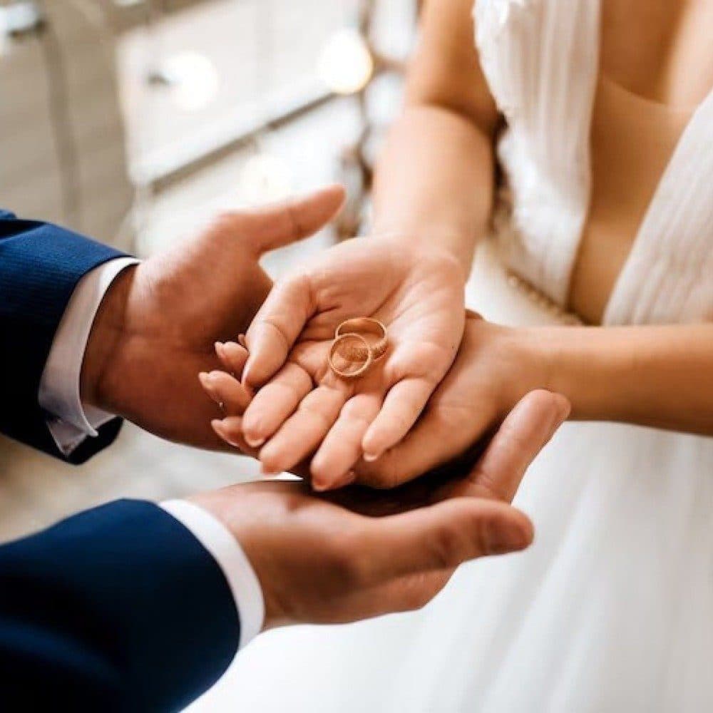 Alianças de casamento sobre documentos, representando o registro de casamento estrangeiro