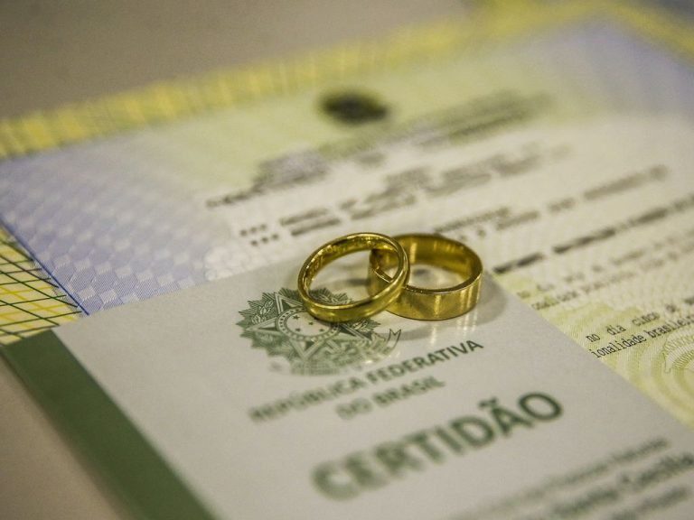 Duas alianças douradas sobre uma certidão da República Federativa do Brasil