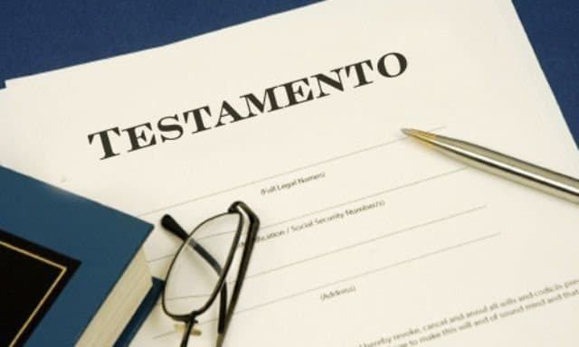 Documento de testamento sobre a mesa, ao lado de balança da justiça