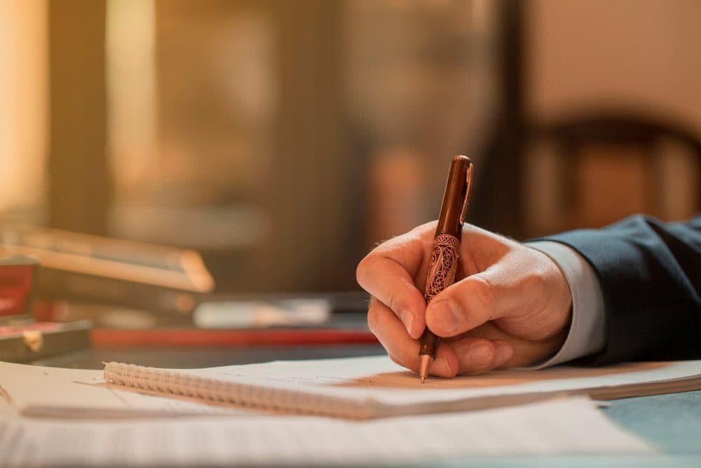 Mãos digitando em notebook representando diretivas de fim de vida